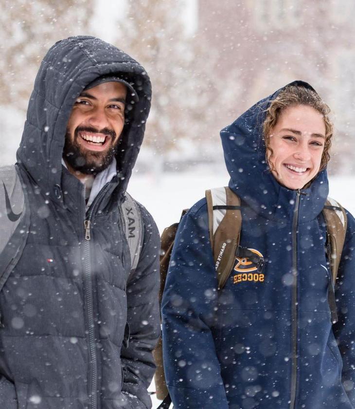 Two students walking in 的 snow